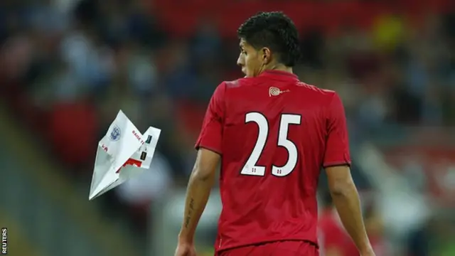 Peru defender Hansell Riojas surprised by a paper plane