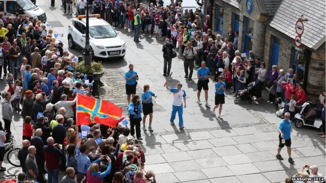 Robert Oag carries the Glasgow 2014 Queen's Baton through Stromness on the Orkney Islands.