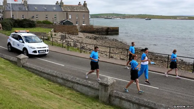 Karen Crichton carries the Glasgow 2014 Queen's Baton through Stromness on the Orkney Islands