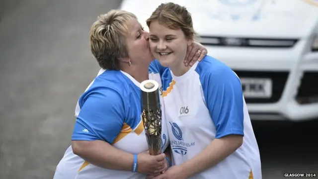 Diane Smith hands the Glasgow 2014 Queen's Baton to her mother, Batonbearer 017 Gaynor Smith