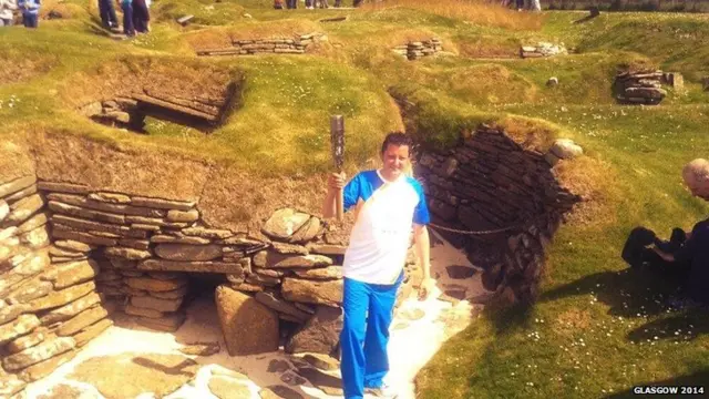 Man holds baton in Skara Brae