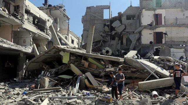 Palestinians inspect the rubble of a building in Gaza city that was hit by Israeli rocket fire