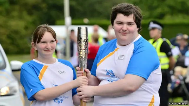 Rachael Mitchell and John Robertson pose with Queen's baton