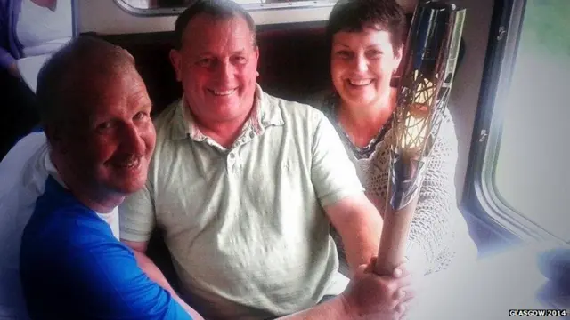 Baton bearer David Sedgewick poses with couple on train