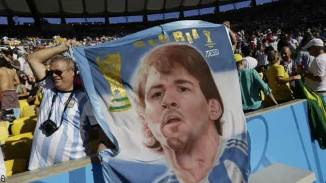 Argentina fan holds flag depicting Lionel Messi as a religious icon