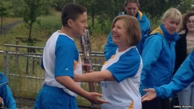 Baton bearer Ann O'Neill receives the baton in Port Glasgow