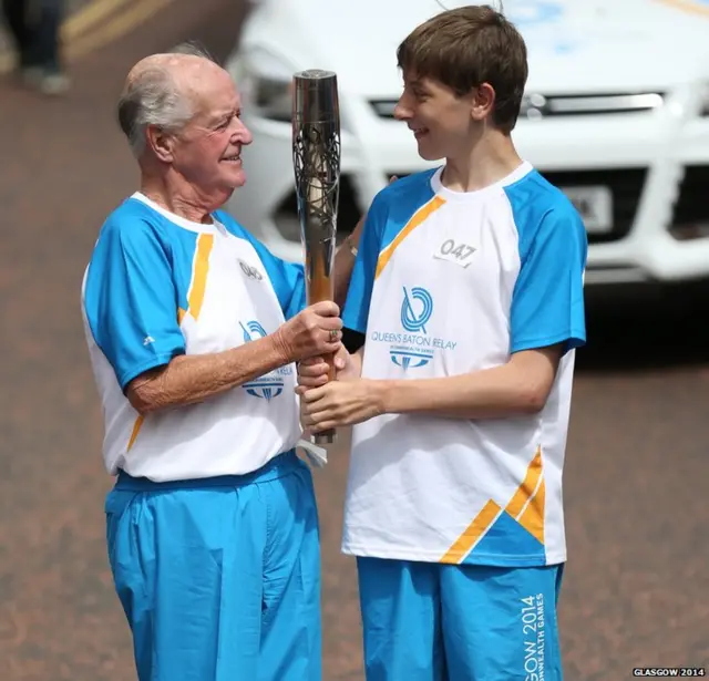 Connor Smith hands the Glasgow 2014 Queen's Baton to Batonbearer 048 William Haining