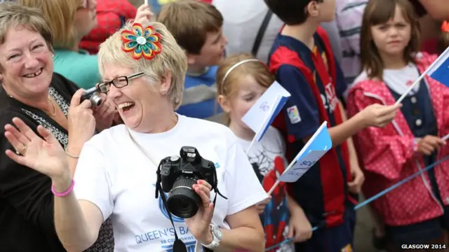 Members of the public welcome the Glasgow 2014 Queen's Baton through Dalry in North Ayrshire.