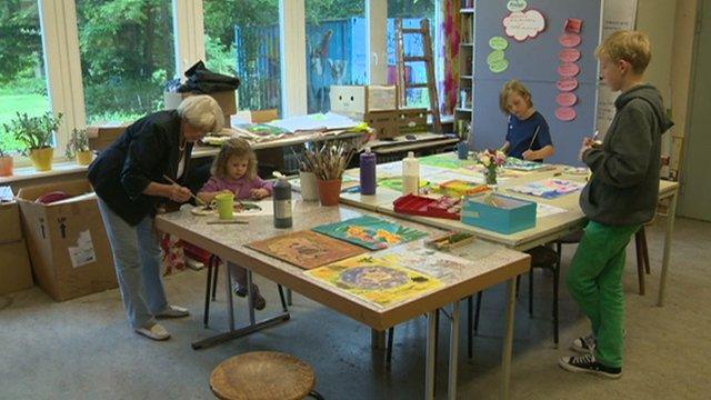 Older woman teaching children art