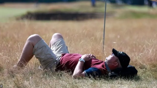 A man takes a nap on the course