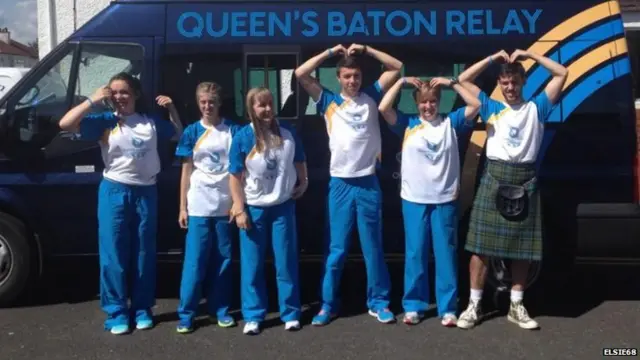 Baton bearers, some of whom are doing Mo Farah's 'mo-bot' sign