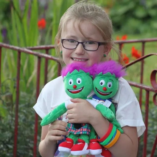 Young girl holding two Clyde mascots