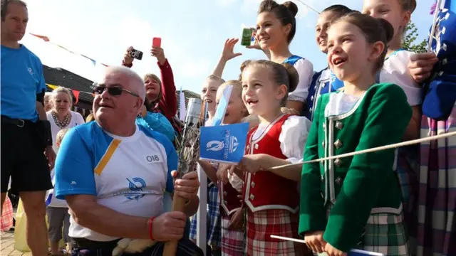 Baton bearer with traditional Scottish dancers