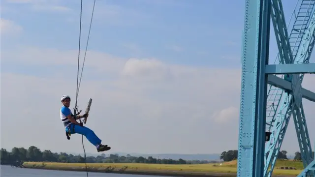 Baton bearer dangling from crane