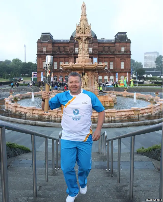 Baton bearer in front of large ornamental fountain