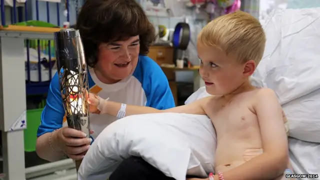 Baton bearer Susan Boyle shows Queen's baton to boy in hospital ward