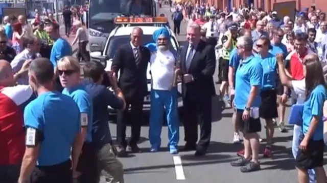 Mark Hateley (left) and Derek Johnstone (right) pose with baton bearer Dilawer Singh for a photograph