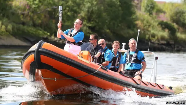 Jordan Robertson has the honour of holding baton as it travels by boat on the River Clyde