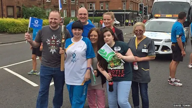 Female baton bearer poses with family