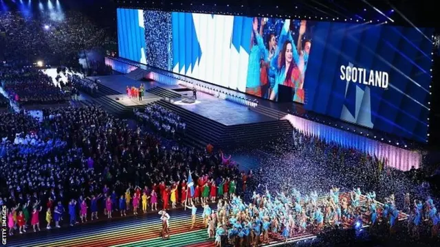 Flag bearer and judoka Euan Burton leads the Scottish athletes