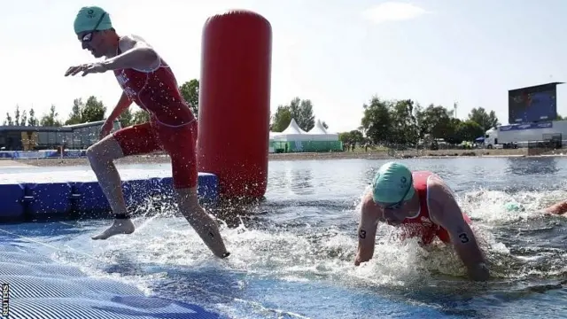 Jonathan Brownlee (L) and and his brother Alistair Brownlee finish the swim