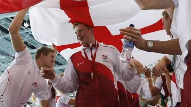 England's Adam Peaty, a member of the winning team, walks through a guard of honour