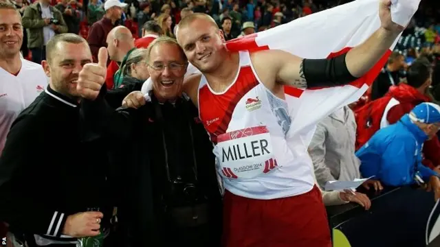 Nick Miller celebrates winning silver in the hammer with his father Lenny