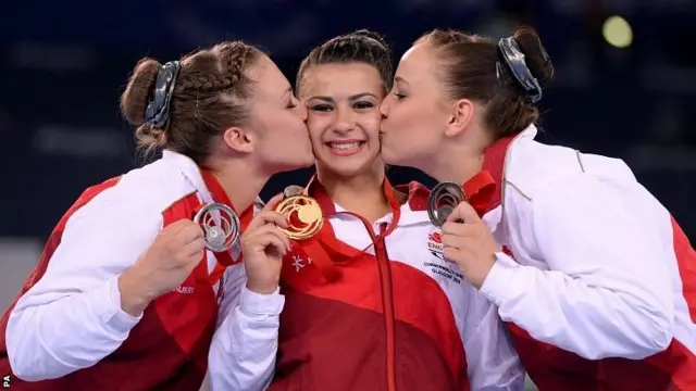 Claudia Fragapane (Gold Medal) is kissed by compatriots Ruby Harrold (Silver Medal) and Hannah Whelan (Bronze Medal)