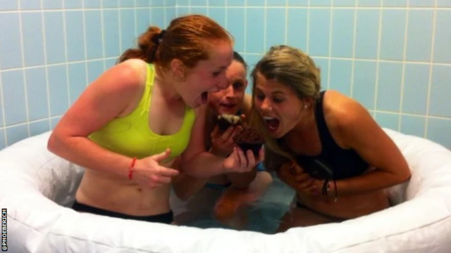 Athletes eat muffins in ice bath