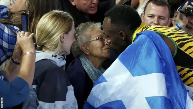 Usain Bolt kisses a woman in the stands