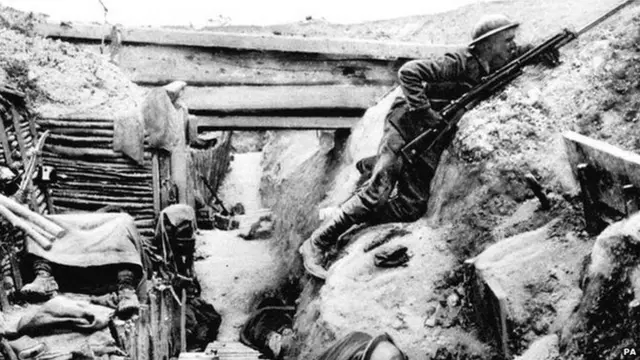 British Grenadier Guardsman keeping watch as his comrades sleep in a captured German trench at Ovillers, near Albert, during the Battle of the Somme in 1916