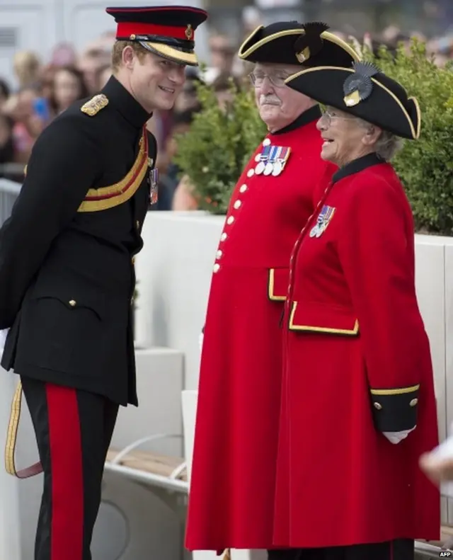 Prince Harry (L) talks with Chelsea Pensioners