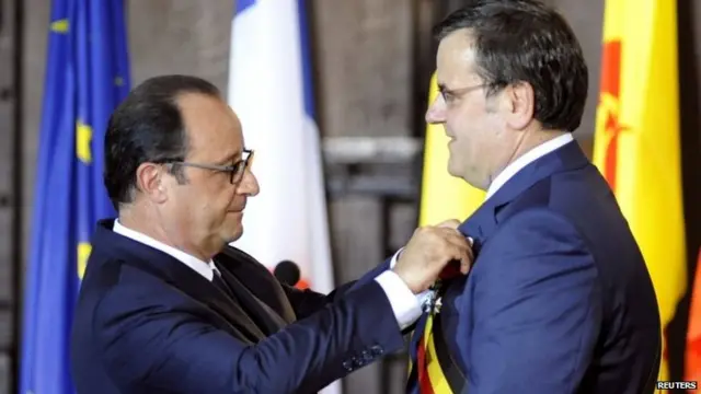 French President Francois Hollande (L) awards the Legion of Honor to Liege Mayor Willy Demeyer