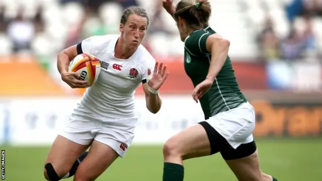 Kat Merchant of England avoids a tackle by Alison Miller of Ireland