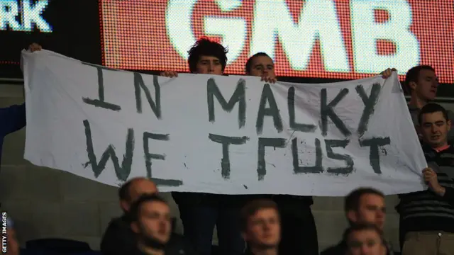 A banner supporting Malky Mackay is held aloft