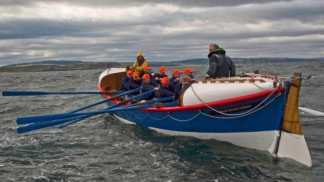 People rowing a lifeboat in the sea