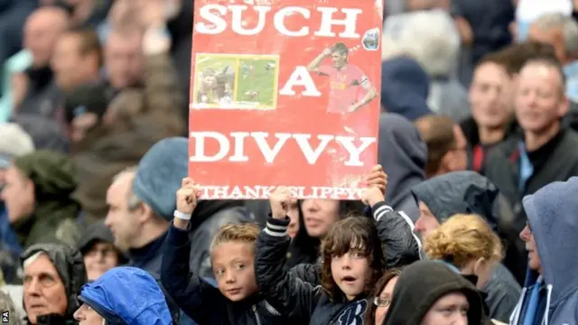 Young Manchester City fans hold a sign