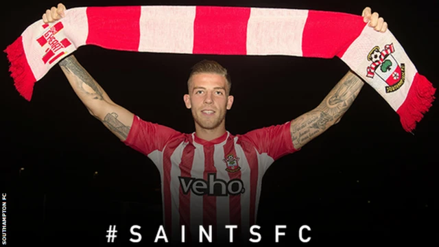 Toby Alderweireld holds a Southampton scarf a loft