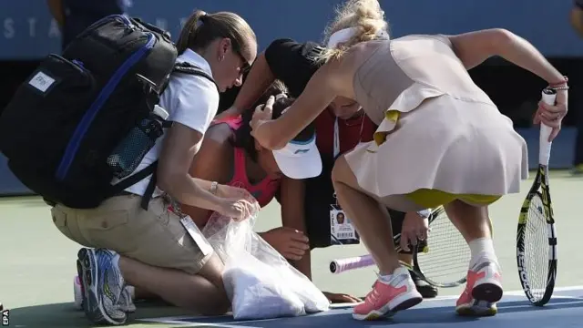 Caroline Wozniacki of Denmark (R) checks on Peng Shuai