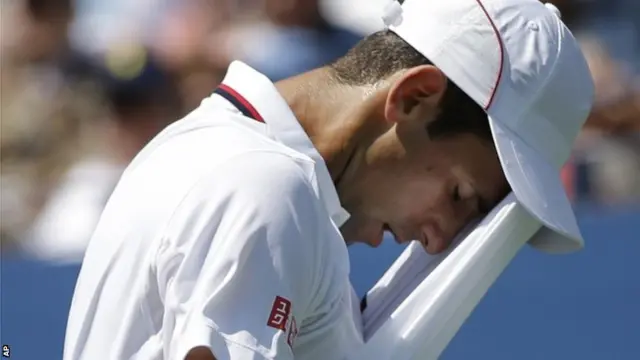 Novak Djokovic, of Serbia, wipes sweat from his face