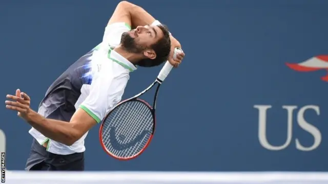 Marin Cilic of Croatia serves to Roger Federer of Switzerland