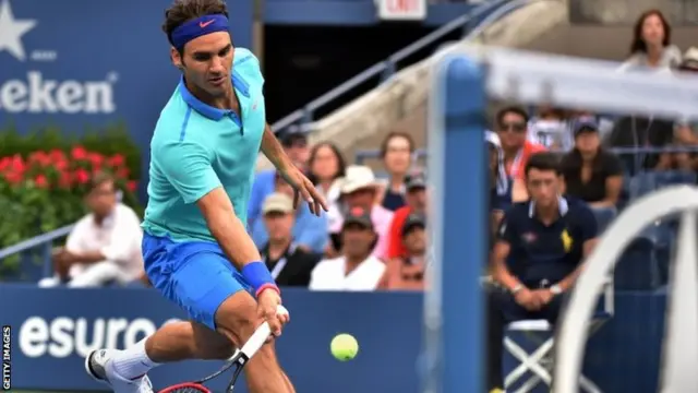 Roger Federer of Switzerland returns a shot to Marin Cilic