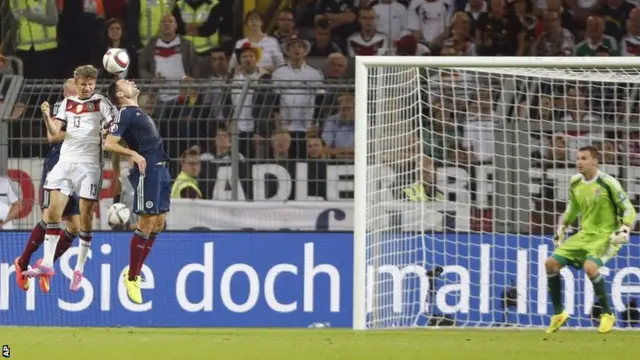 Germany's Thomas Mueller, left, heads the ball toward goal