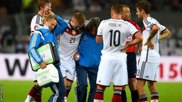 An injured Marco Reus of Germany is carried off the pitch