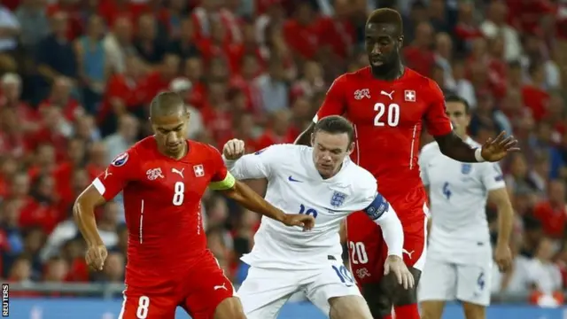 Wayne Rooney (centre) is closed down by Johan Djourou