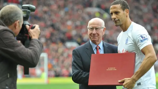 Sir Bobby Charlton hands a gift to ex-Manchester United defender Rio Ferdinand