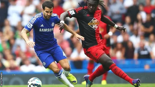 Cesc Fabregas (left) holds off Swansea's Bafetibis Gomis