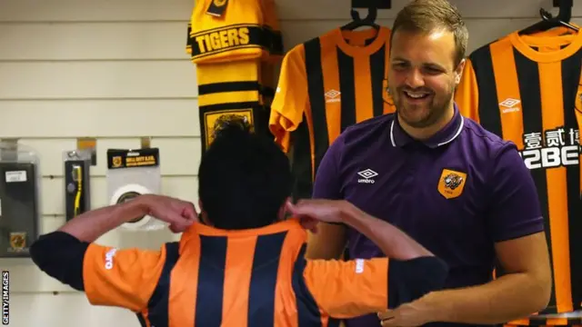 A Hull fan buys a shirt at the KC Stadium