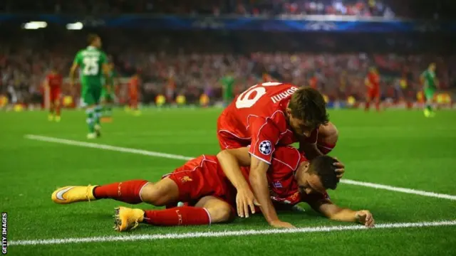 Fabio Borini of Liverpool tends to Javi Manquillo of Liverpool after he was brought down for a penalty