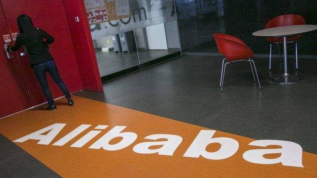 A woman stands next to a door inside the headquarters of Alibaba in Hangzhou, Zhejiang province